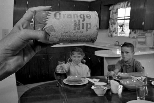 Can of Orange Nip frozen orange juice with eager children waiting in the background.