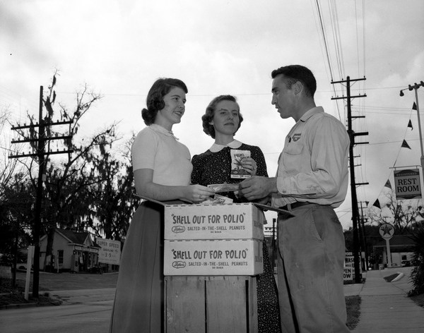 Man buying peanuts from young women raising money to fight polio in Tallahassee, Florida.
