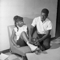 Willie Kelly giving Gwendolyn Thomas a hand in lacing her skates at the Dade Street Recreation Center skating party in Tallahassee.