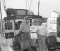 A young woman with two men in yacht "West Wind" at anchor - Pompano Beach, Florida.