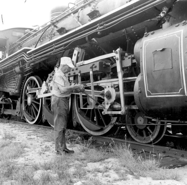 An employee maintaining a steam locomotive of the Gold Coast Railroad Museum - Fort Lauderdale, Florida