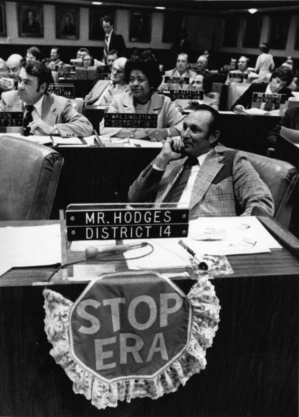 Representative Gene Hodges with STOP ERA sign draped from his desk in the House chamber, ca. 1972. Photograph by Donn Dughi, State Archives of Florida.