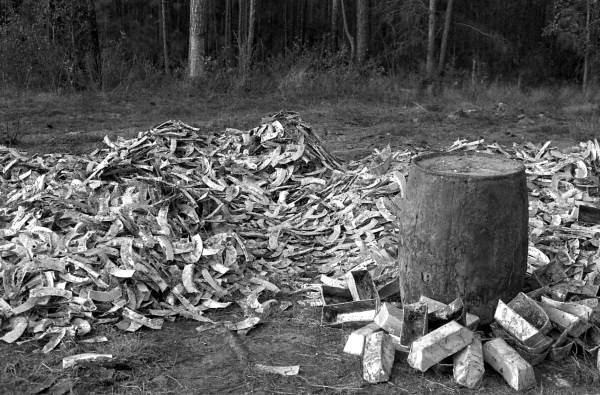 Empty containers that had contained turpentine are strewn around a barrel now filled with the substance.