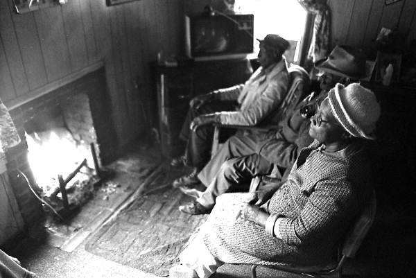 Basket maker Lucreaty Clark and friends sitting around a fire at Clark's house- Lamont, Florida