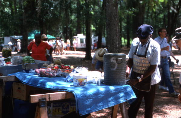 Street crier Tommy Walton getting a drink from water cooler at the Florida Folk Festival - White Springs, Florida.