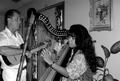 Jesus Rodriguez playing cuatro while apprentice Cecilia Santos plays Venezuelan harp- Miami, Florida