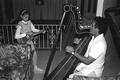 Jesus Rodriguez playing Venezuelan harp while apprentice Ana Maria de Armas plays the cuatro- Miami, Florida.