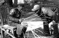 Apprentice Michael Steen (R) watches teacher Alphonso Jennings make a white oak basket - Lamont, Florida