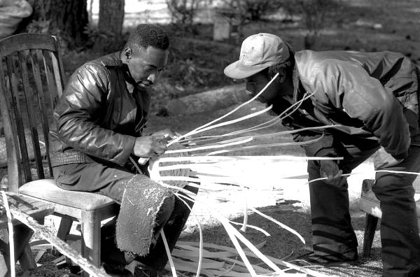 Apprentice Michael Steen (R) watches teacher Alphonso Jennings make a white oak basket - Lamont, Florida