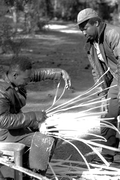 Apprentice Michael Steen (R) watches teacher Alphonso Jennings make a white oak basket - Lamont, Florida
