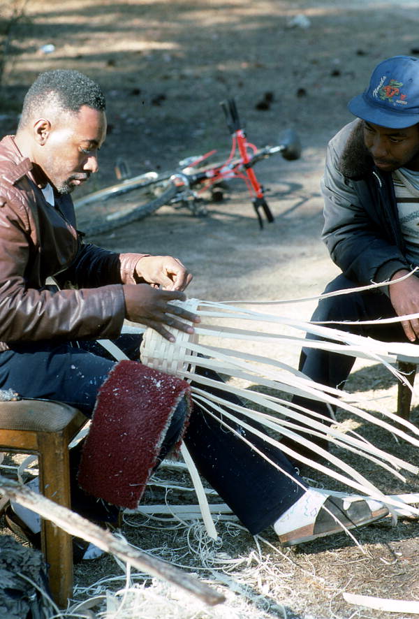 Apprentice Michael Steen (R) watches teacher Alphonso Jennings make a white oak basket - Lamont, Florida