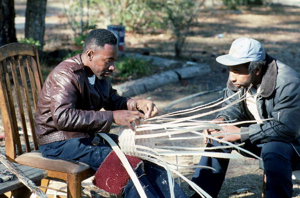 Apprentice Michael Steen (R) watches teacher Alphonso Jennings make a white oak basket - Lamont, Florida