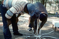 Apprentice Michael Steen (L) watches teacher Alphonso Jennings as he lays out the pattern of a white oak basket - Lamont, Florida