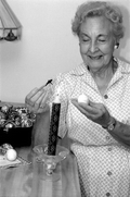 Ola Kryway decorating an Easter egg by applying melted beeswax with a kystka - Titusville, Florida.