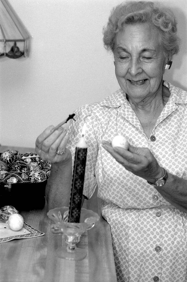 Ola Kryway decorating an Easter egg by applying melted beeswax with a kystka - Titusville, Florida.