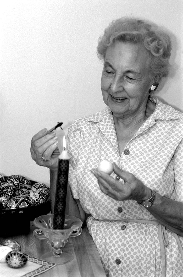 Ola Kryway decorating an Easter egg by applying melted beeswax with a kystka - Titusville, Florida.