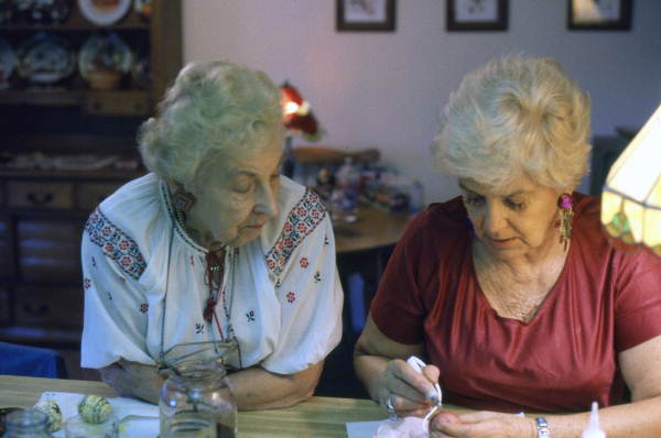 Ola Kryway (L) looks on as apprentice Mary Martin decorates an Easter egg using the Ukrainian pysanky technique - Titusville, Florida.