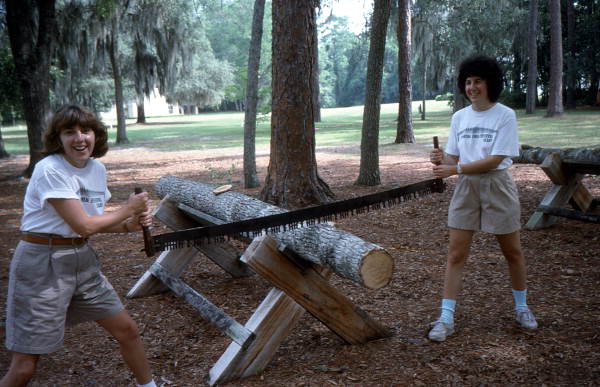 Debbie Fant, left, and Riki Saltzman sawing log at Fourth of July celebration - White Springs, Florida