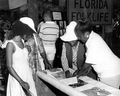 Basket maker Lucreaty Clark and other women look over a quilt at the Folk Festival- White Springs, Florida