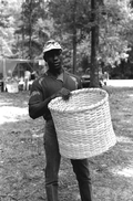 Alfonso Jennings at the 1983 Florida Folk Festival holding a basket he made - White Springs, Florida