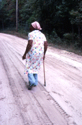 Basket maker Lucreaty Clark walking down a dirt road