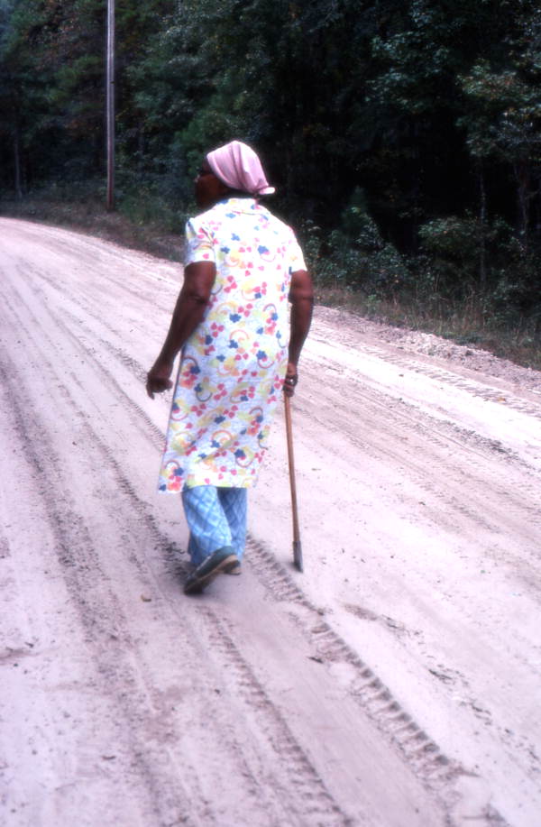 Basket maker Lucreaty Clark walking down a dirt road