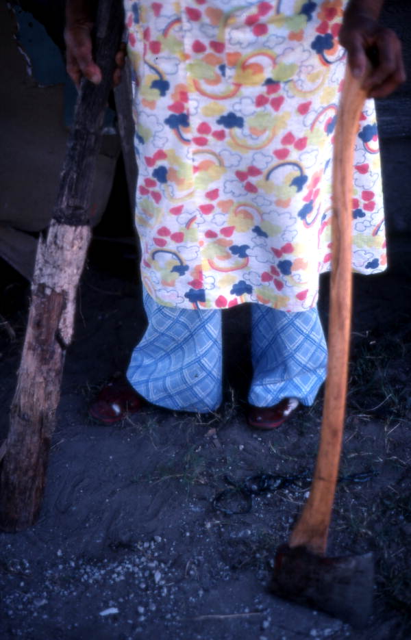 Basket maker Lucreaty Clark holding an axe and piece of white oak tree