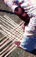 Basket maker Lucreaty Clark laying out strips of white oak