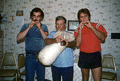 Nikitas Tsimouris playing a tsambouna while George Pilatos (L) and Antonios Tsimouris (R) accompany on practice chanters - Tarpon Springs, Florida