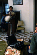 Nikitas Tsimouris playing the tsambouna while folklorist Blanton Owen watches and records- Tarpon Springs, Florida