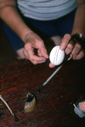 Evelyn Coskey displaying bands of wax during Polish egg decoration (pysanky) - Starke, Florida