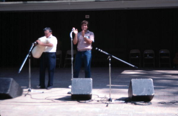 Nikitas Tsimouris playing a tsambouna while his son Tony claps along - White Springs, Florida