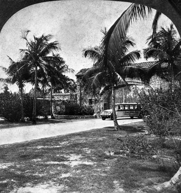 The dramatic Granada Boulevard entrance to Coral Gables, with a tour bus entering through the main archway. This gate was designed by George Merrick's uncle, Denman Fink, and landscape architect Frank Button. It was completed in 1922 (photo also circa 1922).