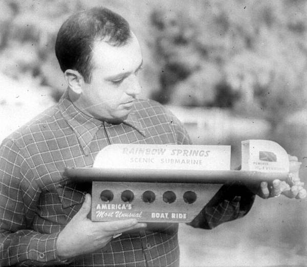 Man holding a model of a Rainbow Springs submarine boat (ca. 1950s).