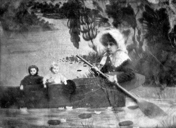 Maud Hamilton Myers Palmer and dolls sitting in a canoe, ca. 1870