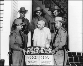 President Harry S. Truman receiving fresh fruit from Florida Highway patrolmen: Key West, Florida (1949)