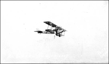 Stuntman hanging from wing of flying Jenny: Daytona Beach, Florida (1923)