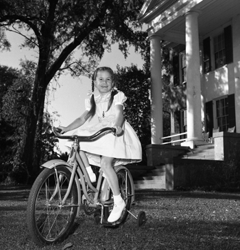 Sara Darby Collins testing her new bicycle at The Grove (1957)