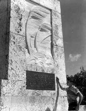 A young man reading the bronze plaque on the memorial for the 1935 hurricane victims: Islamorada, Florida