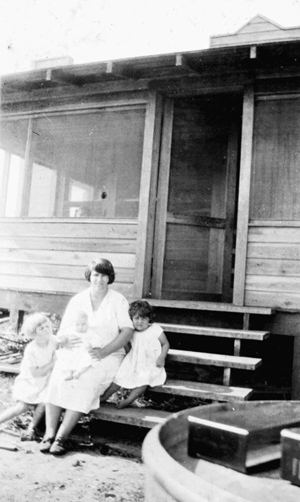 Woman and children on the steps of their new home