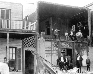 Group of people gathered around building devastated by storm: Cedar Key, Florida (1896)