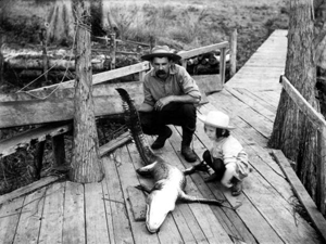 Leigh M. Pearsall and daughter Edna with alligator on dock: Melrose, Florida (ca. 1905)