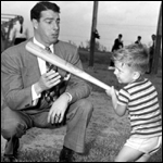 Joe DiMaggio showing three year old Larry Valencourt how to hold a bat: West Palm Beach, Florida (1948)