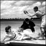 All American Girls Professional Baseball League player Marg Callaghan sliding into home plate as umpire Norris Ward watches: Opa-locka, Florida (1948)
