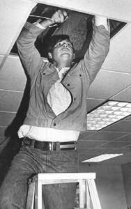 Florida Senator Bob Graham pushing speaker wire into a drop ceiling (1977)