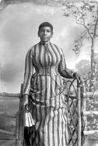 Woman in striped dress, holding a fan