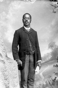 Man in striped tie and pants, holding newspaper