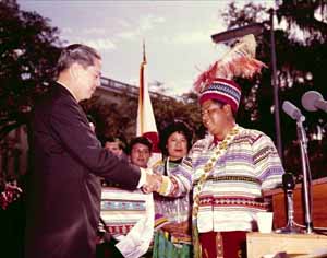 Title: Seminole Tribe of Florida Chairman Billy Osceola presenting Governor Haydon Burns with patchwork jacket at Burn's gubernatorial inauguration: Tallahassee, Florida (1965)