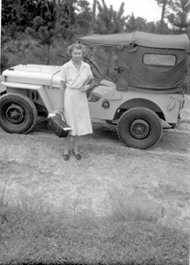 Public health nurse standing beside her jeep (ca. 1948)