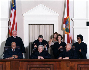 Harry Anstead putting "rabbit ears" on Charles Wells prior to formal en banc portrait of Florida Supreme Court Justices from the year 2000